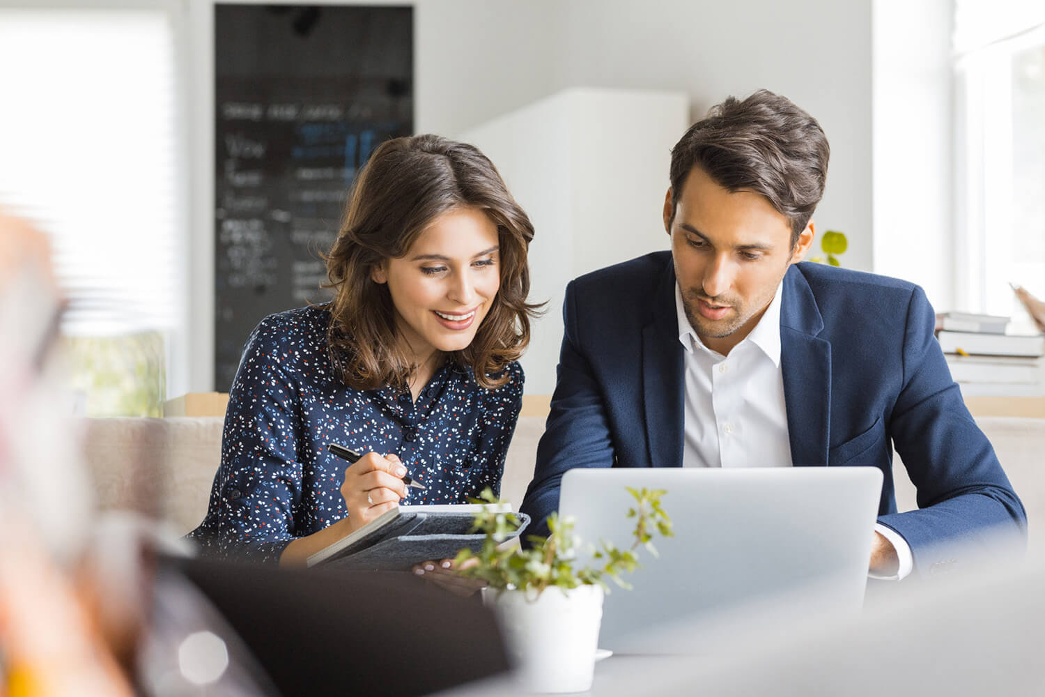  Two employees working together on laptop