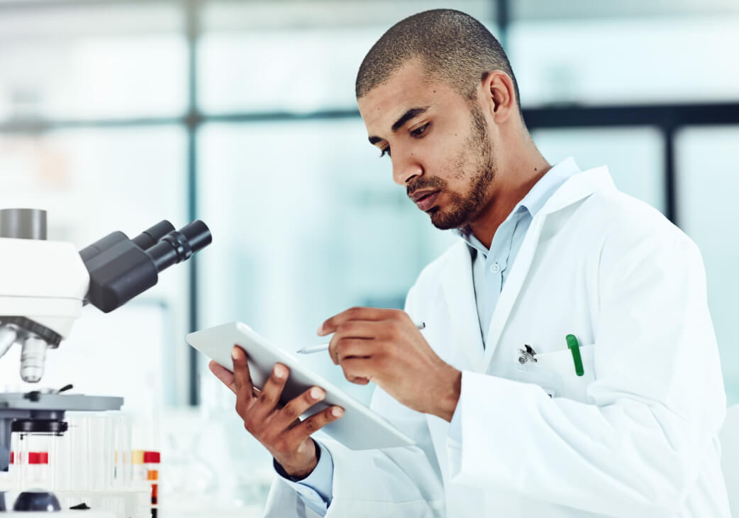 man in a white lab coat viewing a clipboard